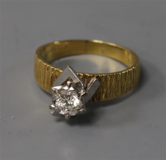 A textured 18ct gold and solitaire diamond ring, size Q.